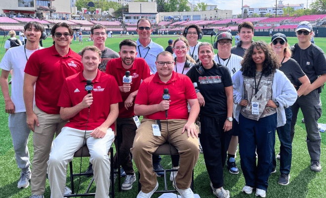 Red Hawk Sports Network students pose for a group photo on the field.