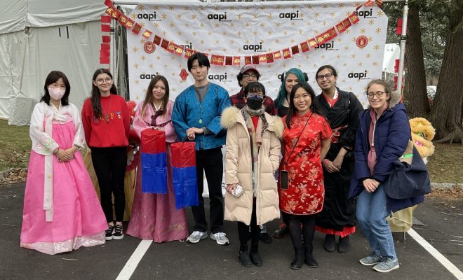 A group of people poses for a photo, with some wearing traditional Korean clothing