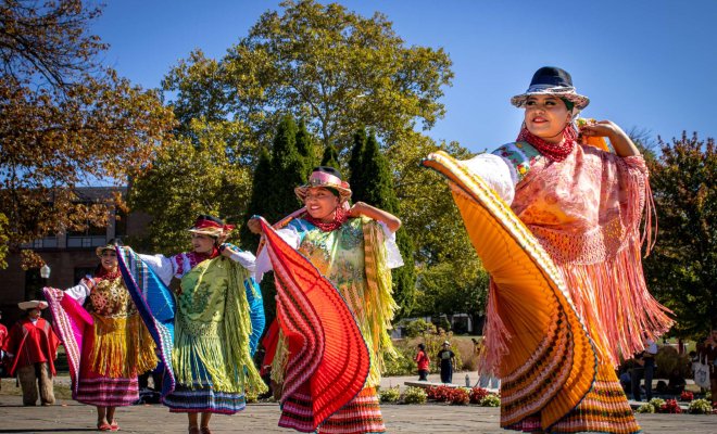 Four female dancers in traditional Peruvian attire performing a dance