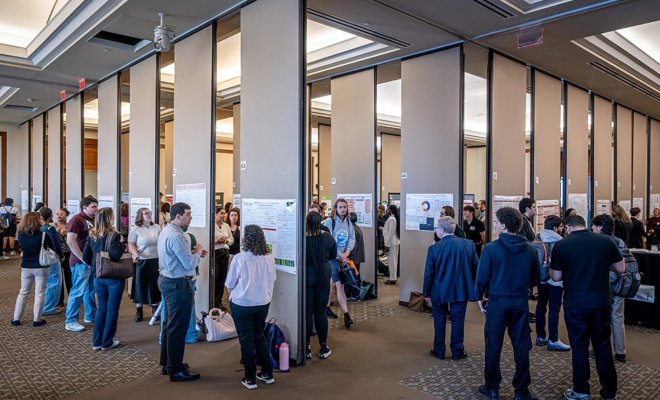 A ballroom crowded with college students presenting projects to judges