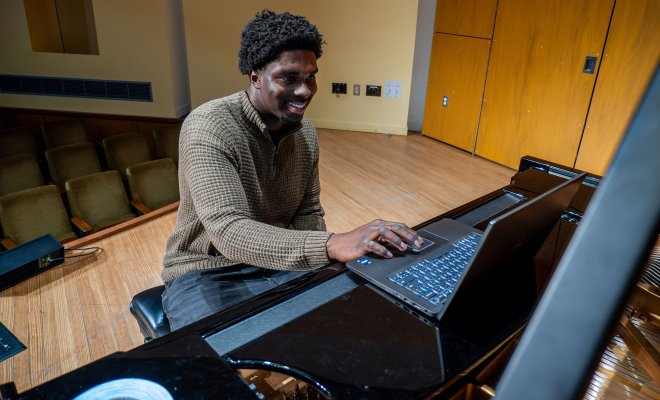 Isaac Afriyie-Addo onstage with a computer.