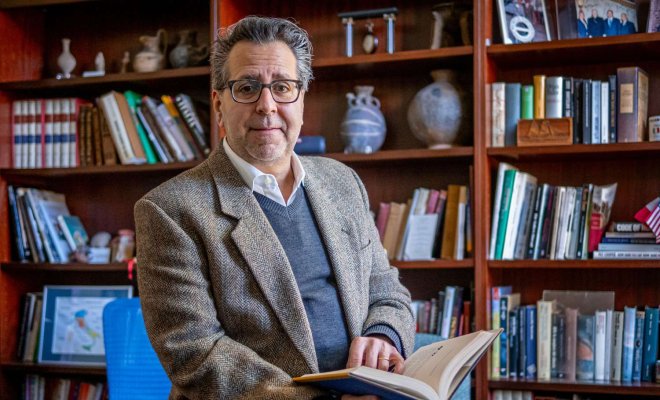 Coccia Director Mark-Rotella seated in a chair in front of bookcases.jpg
