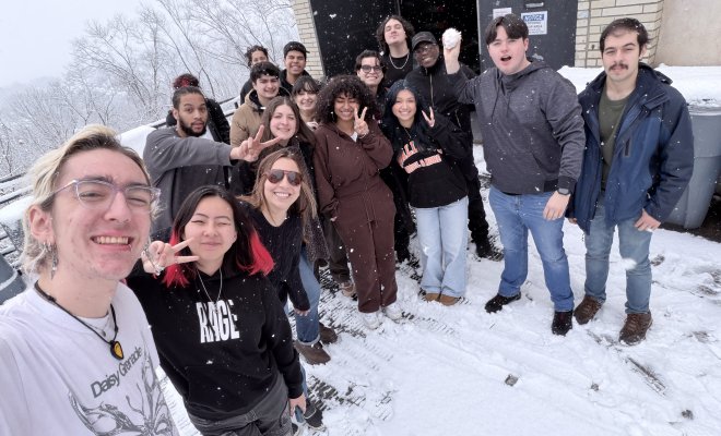 Students and Professor Poland pose for a photo outside.