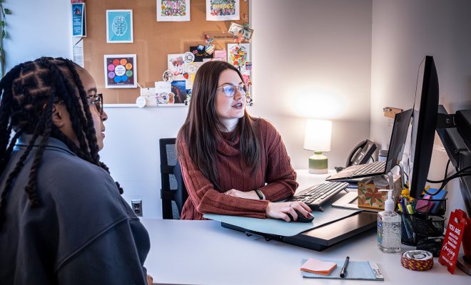 photo of career advisor Macayla Mack with a student in her office for an appointment, they are looking at a computer