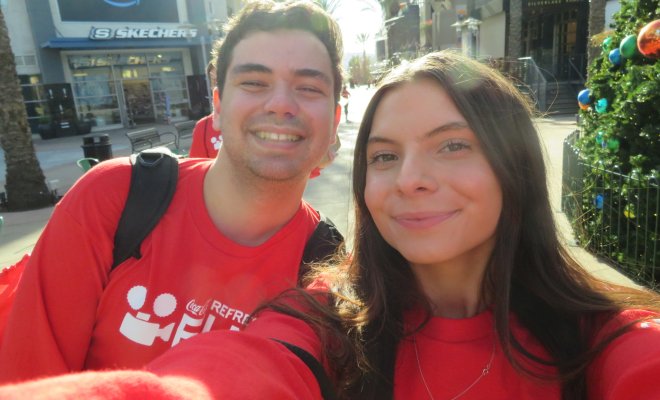 Two students in red shirts smiling in a selfie-style photo.