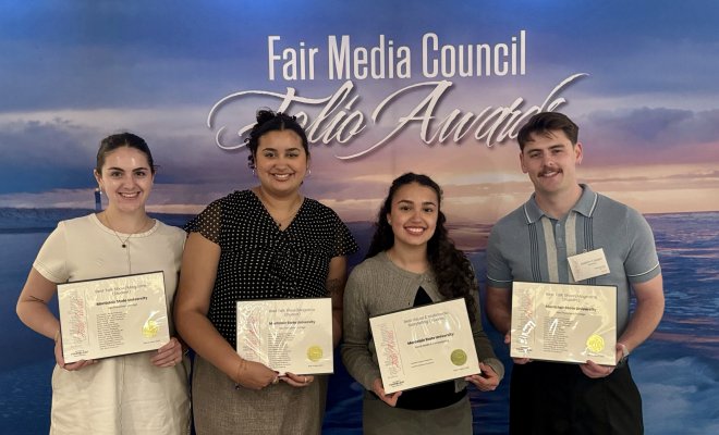 Four students holding their award certificates.