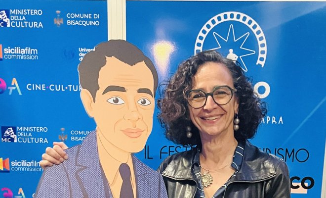 Dr. Teresa Fiore poses with a cartoon-styled cardboard cut-out of film director Frank Capra