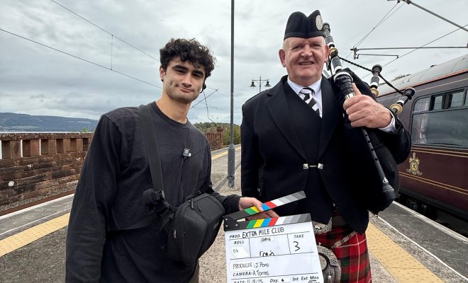 CCOM Alum on set posing with an actor.