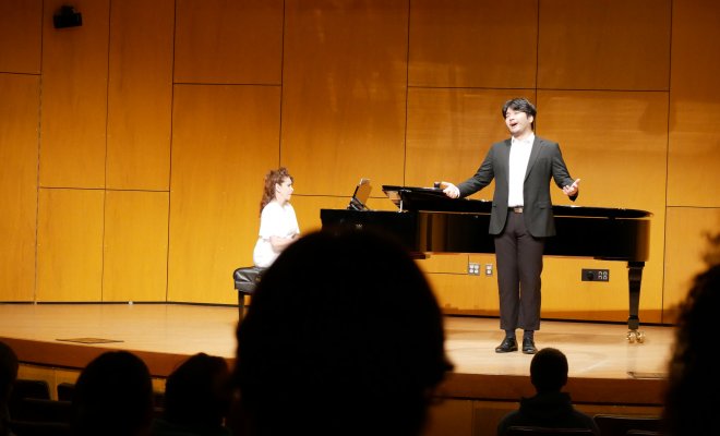 Voice performer on stage with collaborative pianist in front of audience