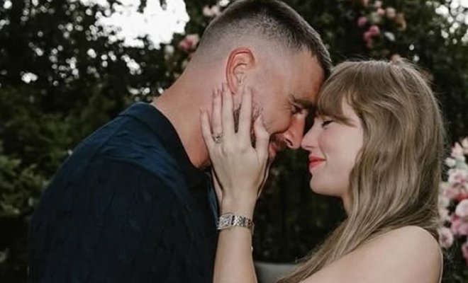 A man and a woman embracing. He is on the left wearing a dark shirt and she is on the right wearing a striped dress.