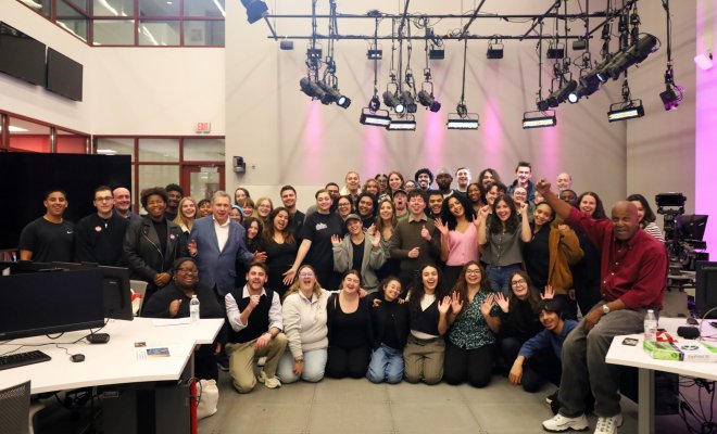 Students and faculty pose for a group photo after production finishes.