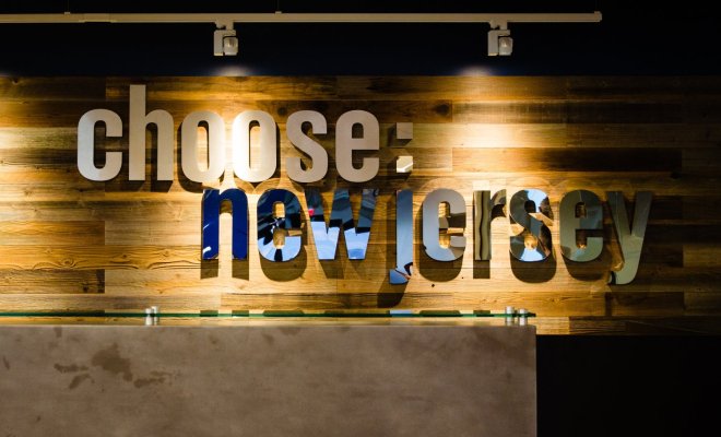 Metal wall sign for "Choose: New Jersey" fixed to a wooden wall fo