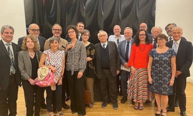 A large group of people pose inside an art museum 