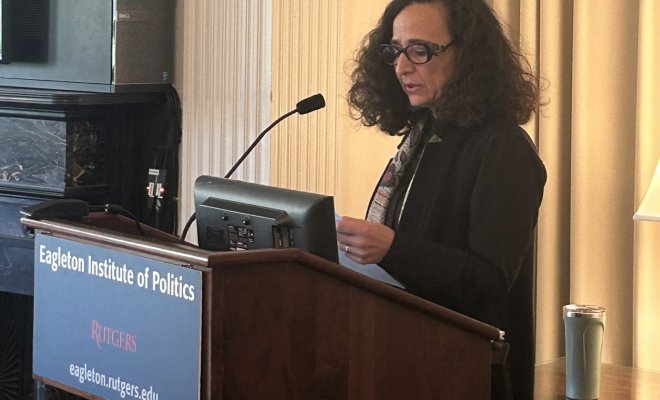 Dr. Teresa Fiore stands at a podium and presents to an audience at Rutgers University