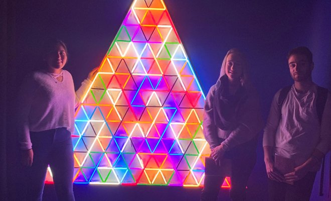 students with illuminated rainbow triangle at museum in NYC