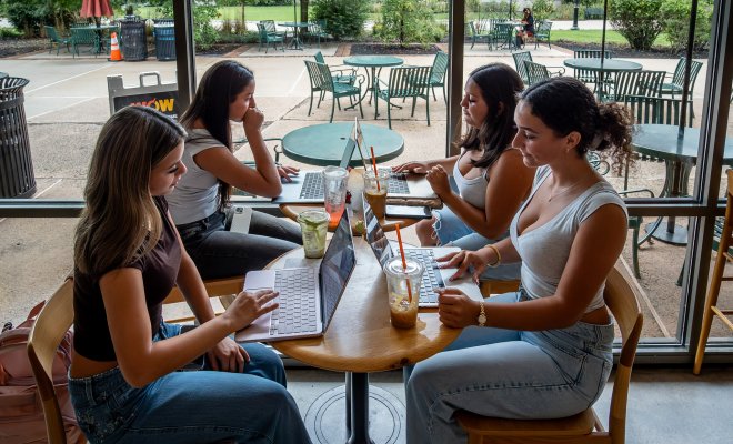 Students on campus on their laptops.