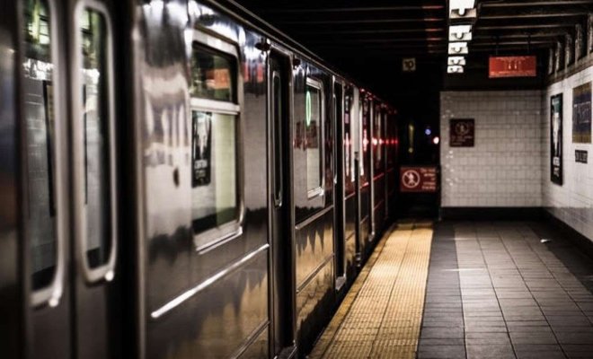 An empty subway platform with a train at the station