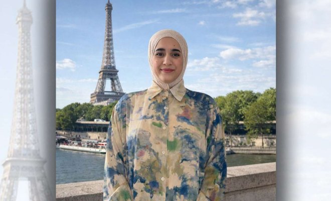 Headshot of Ptissem Assou standing in front of the Eiffel Tower