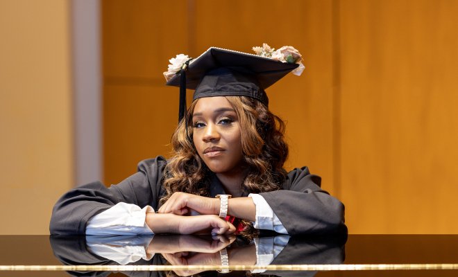 Lanaye Kemp with graduation cap and gown at piano