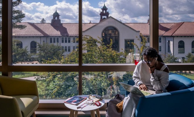 student studying by windows looking over Cole Hall