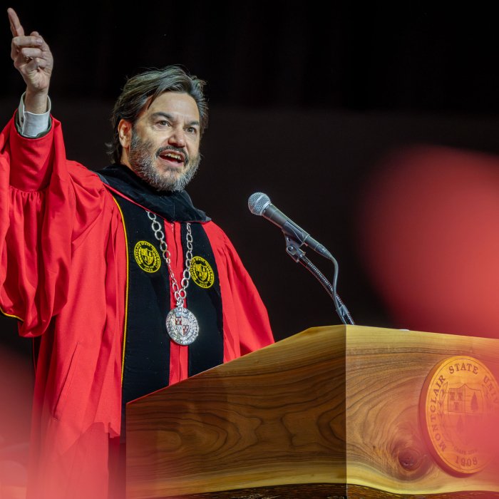 Montclair State University President Jonathan Koppell speaks at the podium during the Winter Commencement ceremony, addressing graduates.