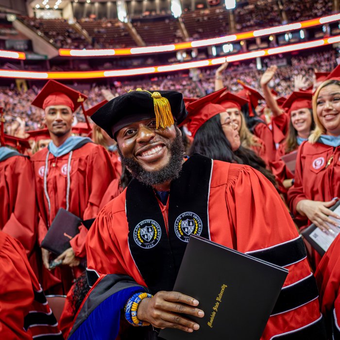 doctoral degree recipient smiles for the camera