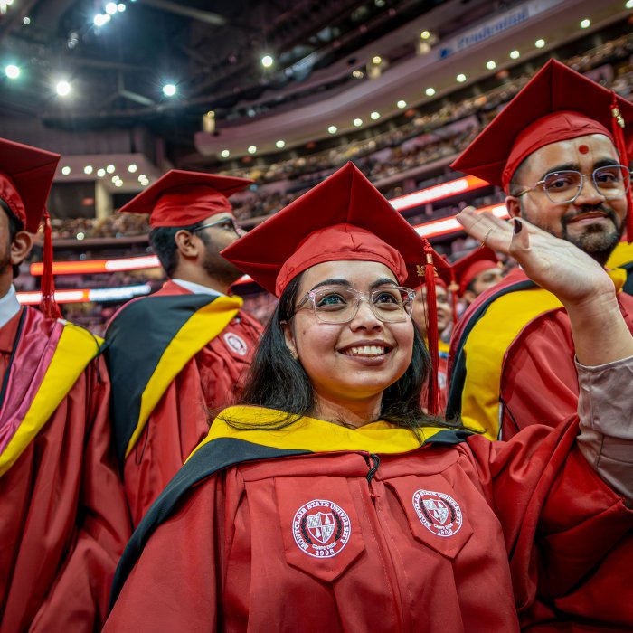 Master's degree candidates in red caps and gowns
