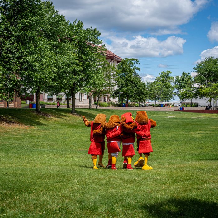 Four students dressed as Rocky walk arm-in-arm along the Quad.