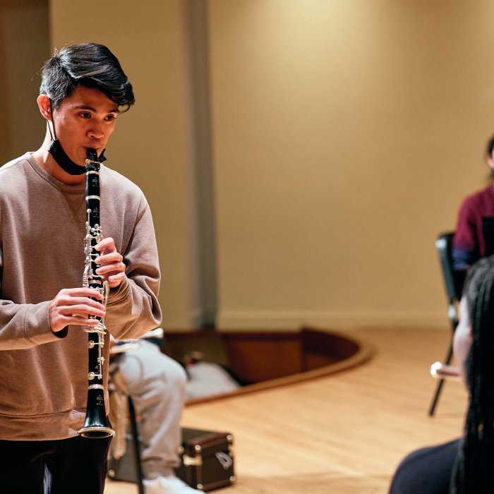 A Male student plays the clarinet.