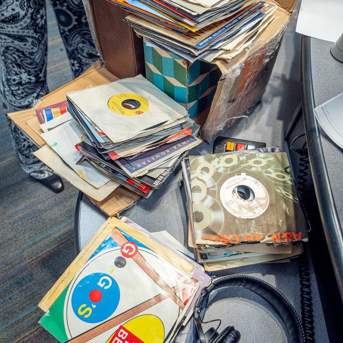 A close up photo of a table with many 45 records