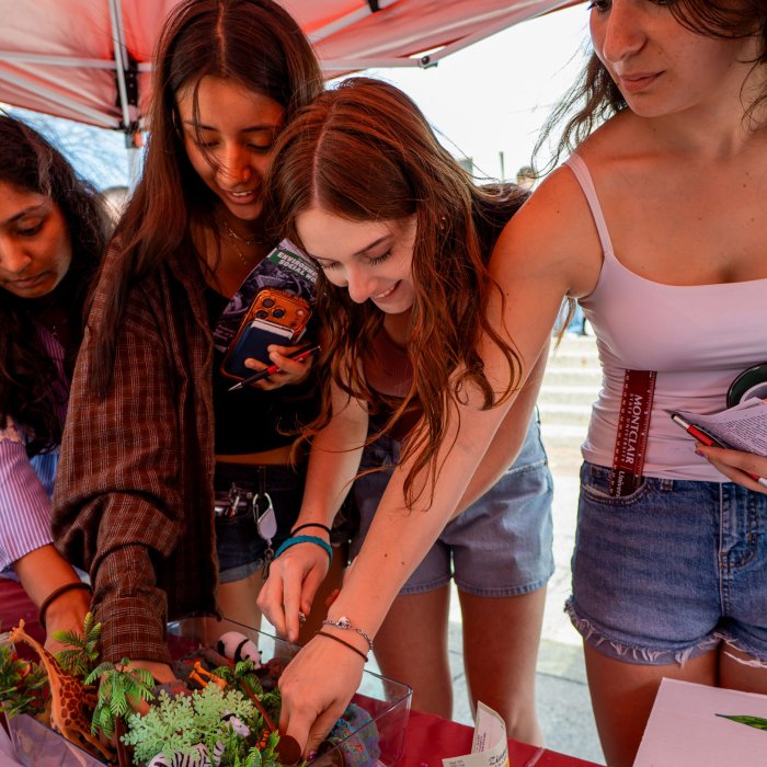 A group of four students participating in the mining game at the Office of Sustainability's table during Earth Day 2026.