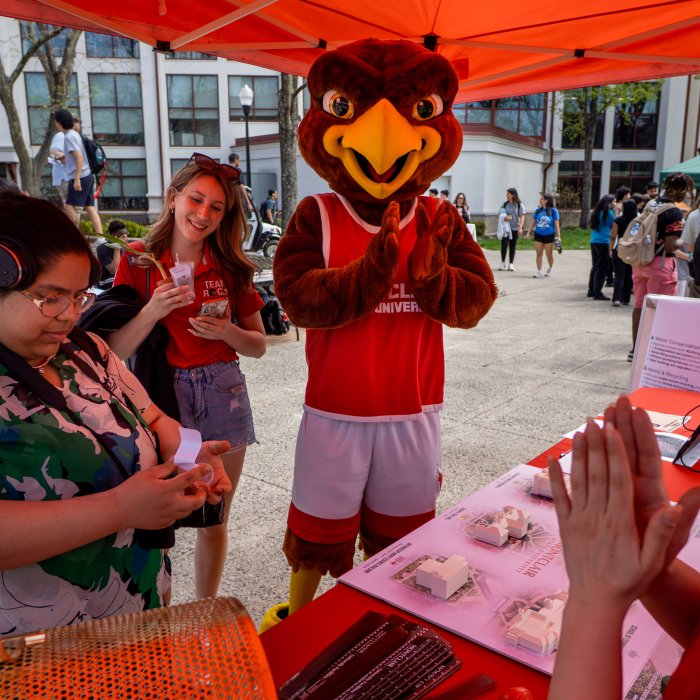 Mascot Rocky looks on and applauds as a student participates in a table activity at Earth Day 2026