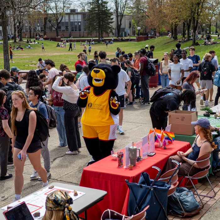 Photo of participants milling around in the Student Center Quad on Earth Day 2026, with mascot Deacon in the center.