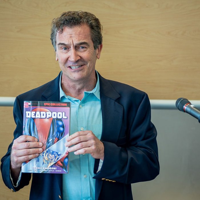 man holding a deadpool book