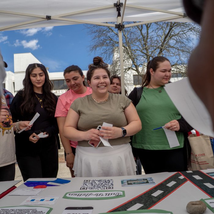 A group of students at an Earth Day table taking part in a game.