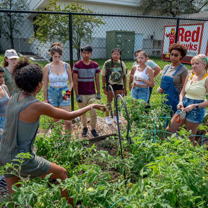 Garden Manager, Brittney Portes, speaks to a group of student gardeners in the garden space.
