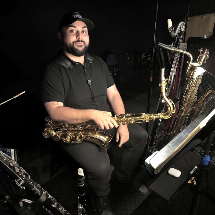 Alex Lemma in orchestra pit with saxophone