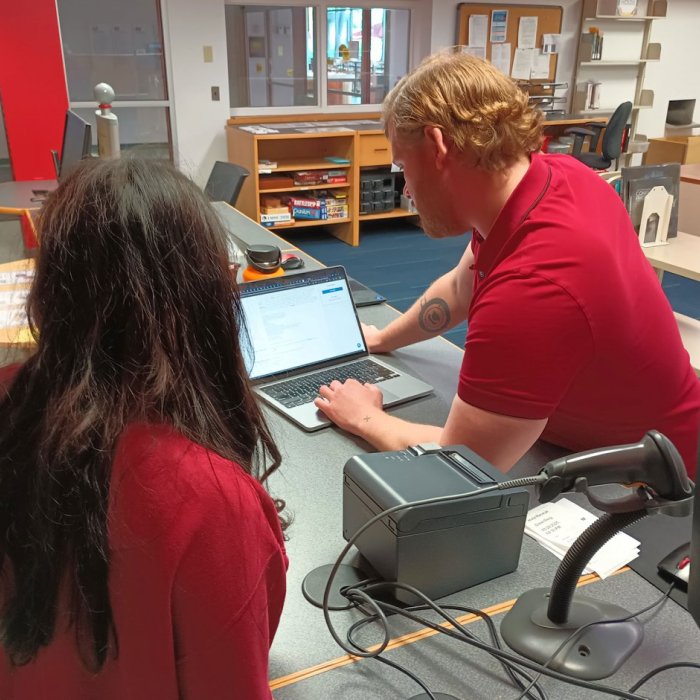 student getting help from librarian at front desk