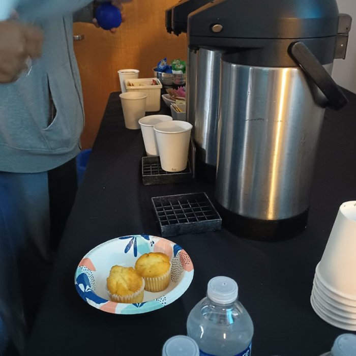 two hot water jugs and a bowl with muffins