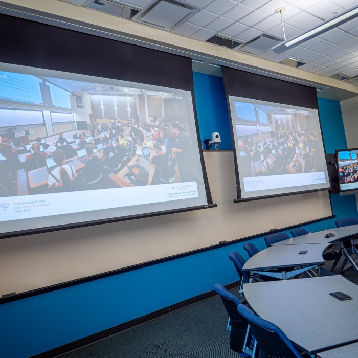 Two projector screens with powerpoint displayed 