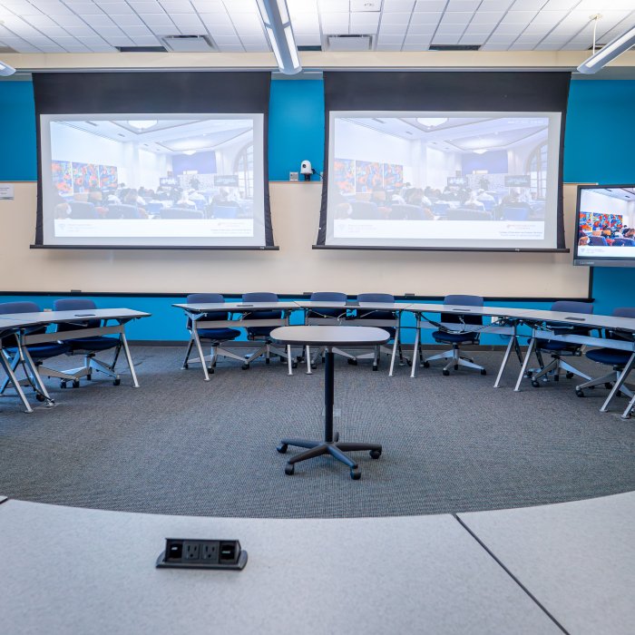 Empty round table with two projectors displaying