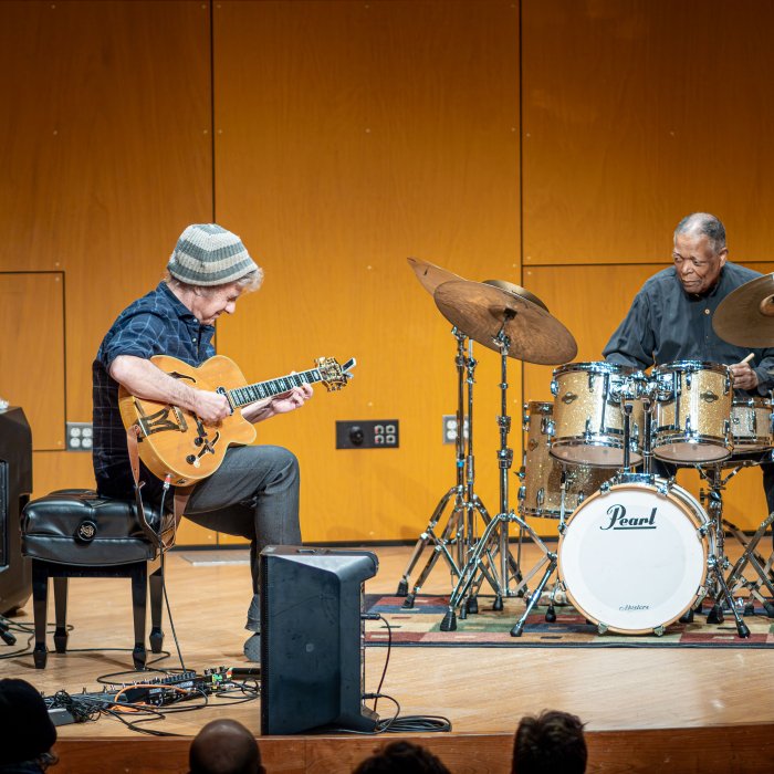 Pat Metheny and Billy Hart on stage performing for students