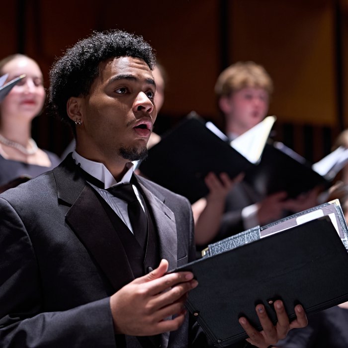 Male Cali Choir performer on stage singing