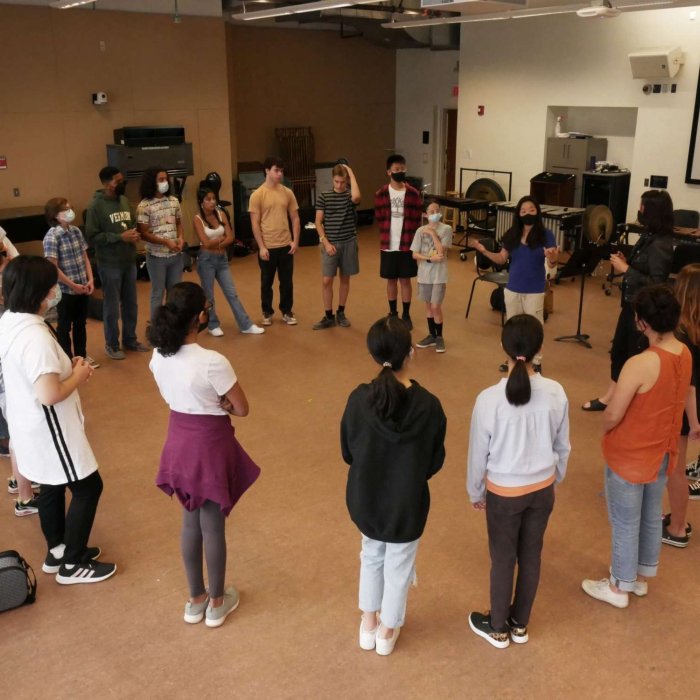 String campers standing in a circle in a workshop