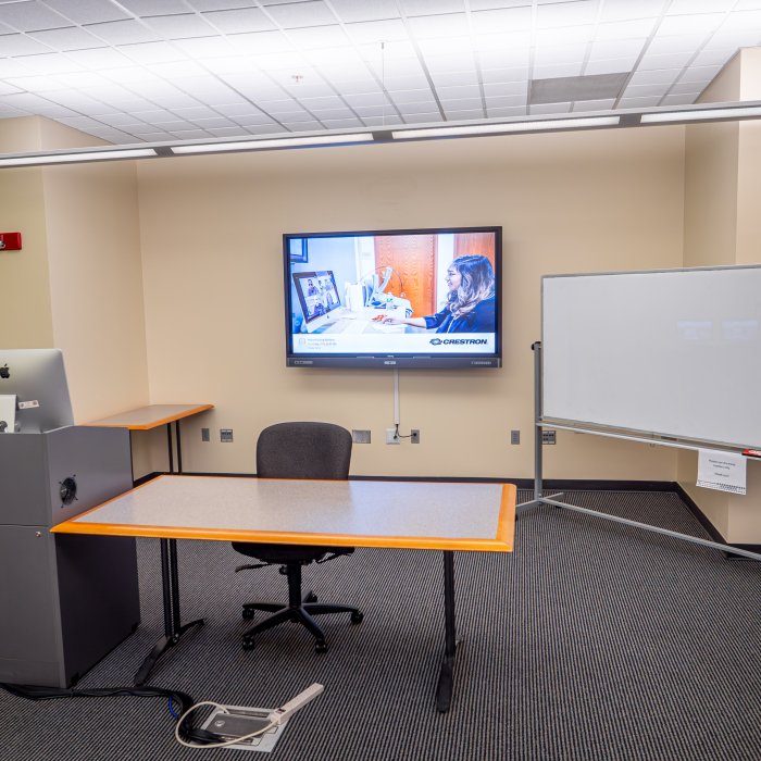 Teachers podium with a whiteboard and screen behind 