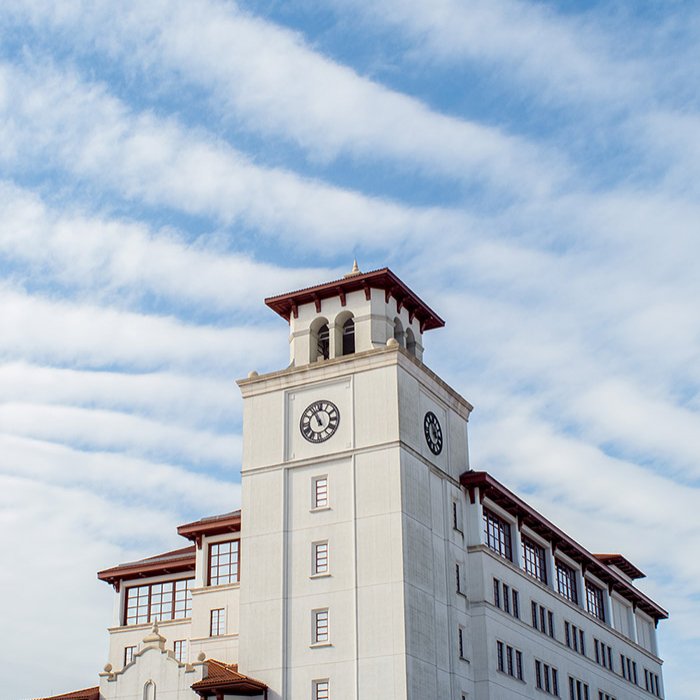 university hall building in front of blue and white sky