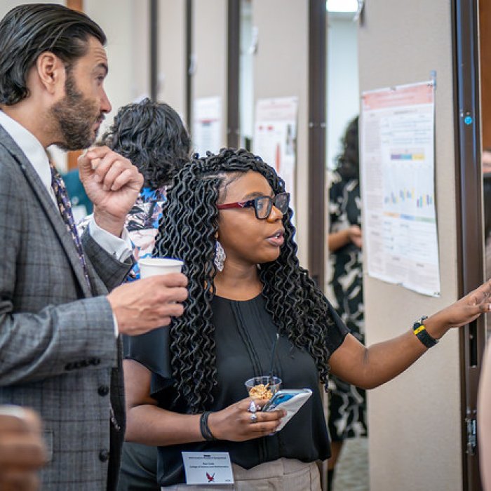 Student presenting poster to President Koppell