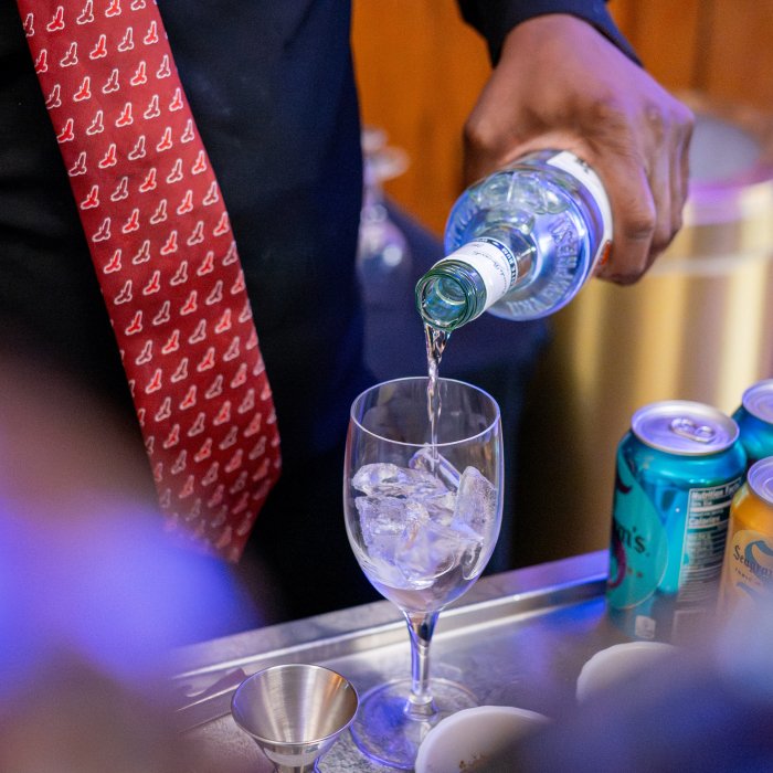 person pouring liquor, red tie