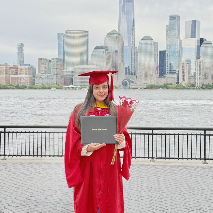 Priyanka Kapoor graduation picture. Student is standing in front of NYC skyline