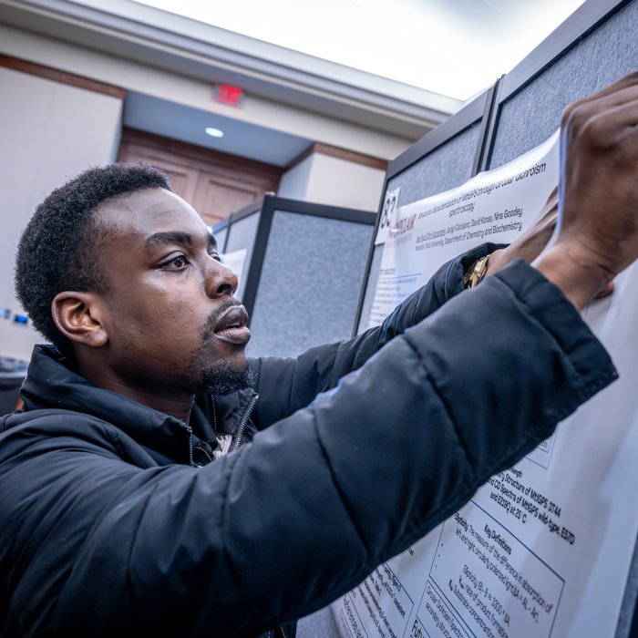 Student hanging up poster